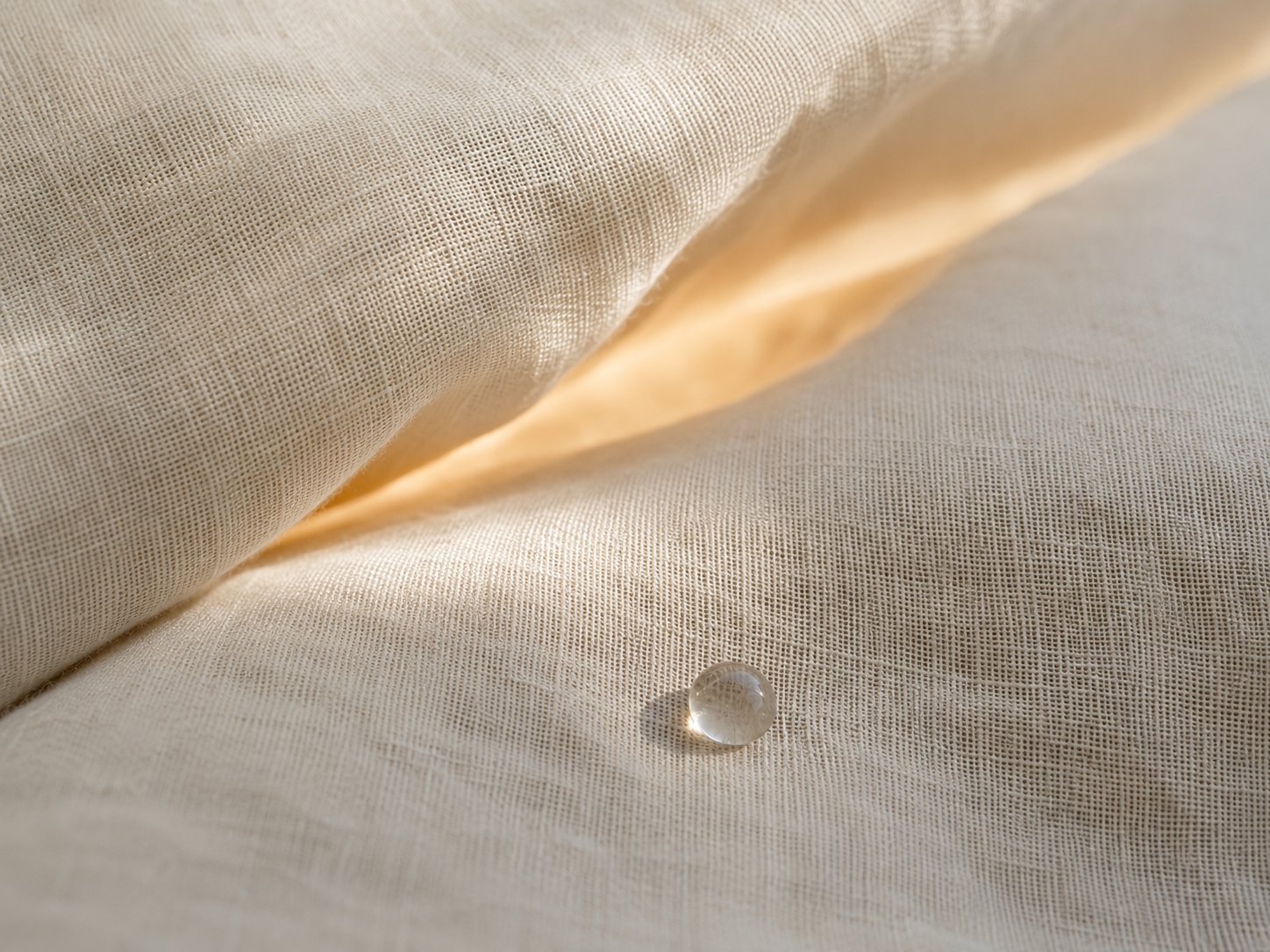 Soft linen layers with a drop of liquid suggesting closeness and embrace distance